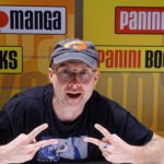 Bartosz Sztybor con gorra y lentes, sentado frente a un fondo de Panini en Comic Con Stuttgart 2025.