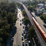 Tren sobre vías elevadas de la Línea 9 junto a Viaducto Río de la Piedad y un recinto deportivo, agosto de 2025.